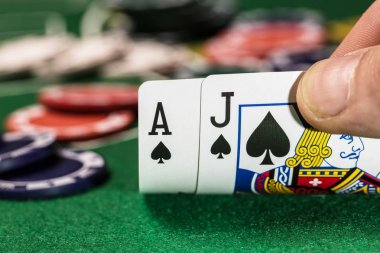 Casino fişleri yeşil kart oyun masasında maça Ace ve Jack kartları oynarken. Kumar arka planı