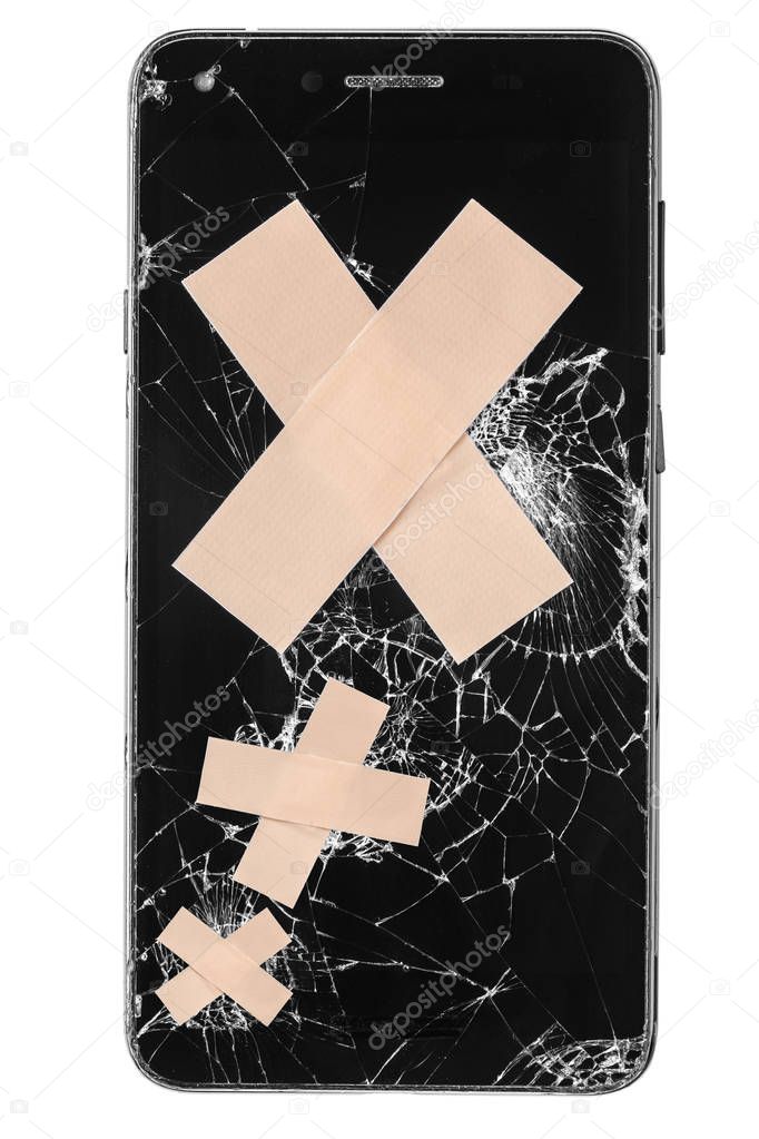 Broken mobile phone / cellphone / smartphone screen with medical patch stitches isolated on white background