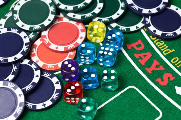 Casino chips and dice on green card game table. Gambling background