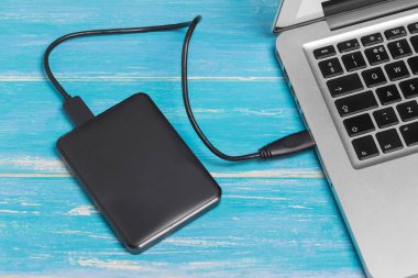 Üst görünüm gümüş dizüstü bilgisayar / kopya alanı ile mavi ahşap masa üzerinde harici sabit disk Hdd ile dizüstü bilgisayar