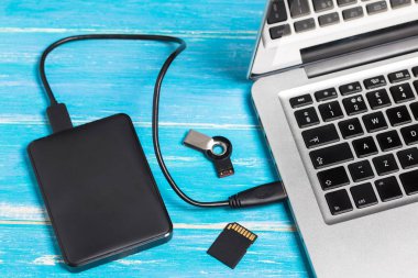 Üst görünüm gümüş dizüstü bilgisayar / kopya alanı ile ahşap masa üzerinde harici sabit disk Hdd ve Sd kart ile dizüstü bilgisayar