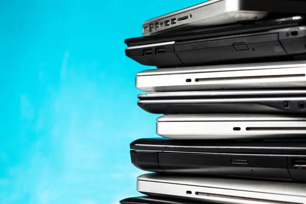 Stack of laptops / notebooks with copy space on blue background