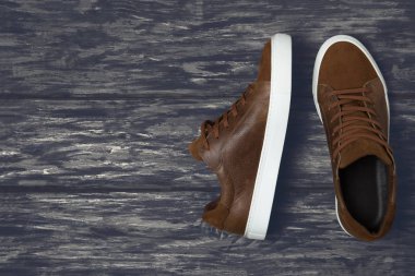 Ahşap zemin üzerinde kopya alanı olan kahverengi deri ayakkabılar.