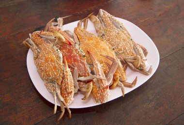 Ahşap masa üzerinde tabak haşlanmış yengeç