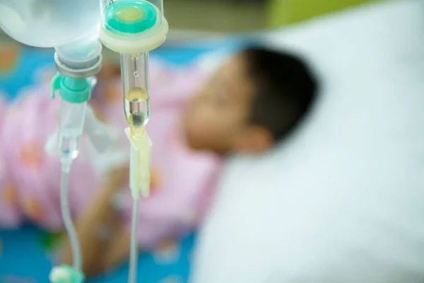 Asyalı bir çocuk hastanedeki yatakta salin damar içi ve seçici odaklı..