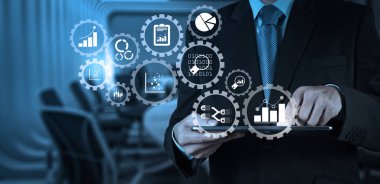 İş verilerini analytics yönetimi ile bağlı dişli KPI mali grafikler ve grafik ile dişliler. İşadamı el Oda arka plan görüşmekte dijital tablet ile çalışma