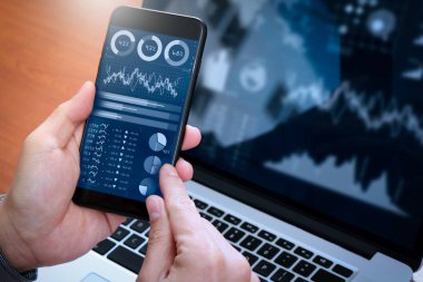Yatırımcı borsa raporu ve finansal gösterge tablosu ile iş zekası (BI), anahtar performans göstergeleri (KPI) ile analiz. Dizüstü bilgisayar ile akıllı telefon kullanan iş adamı.