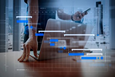 Kilometre taşları ilerleme planlama ve Gantt Grafiği diagram.designer planlama ile proje yöneticisi çalışma ve güncelleştirme görevlerini el çalışma ve akıllı telefon ve ahşap masa ofis dizüstü.