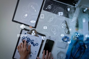 Cep telefonu ve dizüstü bilgisayarı ve stetoskop koyu ahşap masanın üzerinde çalışma akıllı tıp doktoru da tıbbi teknoloji diyagram concept.top manzaralı modern Vr 