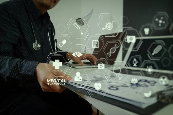 Modern VR with medical technology diagram concept.smart medical doctor working with smart phone and digital tablet and laptop computer and stethoscope on wood desk in modern office