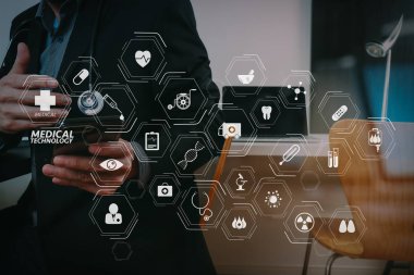 Tıbbi teknoloji diyagram concept.smart tıp doktoru akıllı telefon ve dijital tablet ve dizüstü bilgisayar cam ile modern ofisindeki koyu ahşap masa üzerinde çalışma ile modern Vr görünümü yansıyan