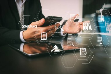 Düzenlemeler, hukuk, standartlar, gereksinimleri ve akıllı telefon ve dijital tablet ve dizüstü bilgisayar cam ile modern ofis çalışma audit.businessman için uyum sanal Diyagramı görünümü yansıyan  