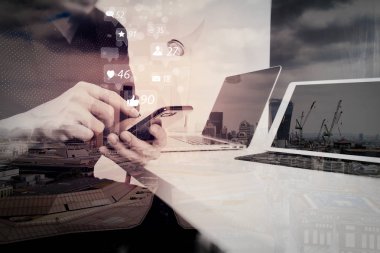 Sosyal medya ve pazarlama sanal simgeler akıllı telefon ve dijital tablet ve dizüstü bilgisayarı ve Londra şehir pozlama ile modern ofis belgede çalışma concept.businessman ekran