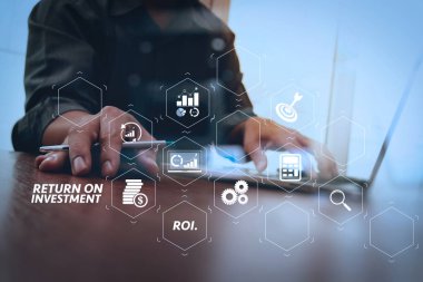 Yatırım getirisi getirisi yatırım göstergesi iş geliştirmek için sanal tablosu içinde. ahşap masa üzerinde dizüstü bilgisayar üzerinde çalışan iş adam el yakın çekim