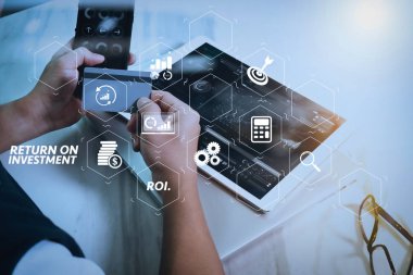 Yatırım getirisi getirisi yatırım göstergesi iş geliştirmek için sanal tablosu içinde. Plastik kredi kartı tutan ve dijital tablet ve dizüstü bilgisayar ile akıllı telefon kullanarak işadamı eller. 