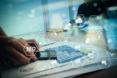 Mobil Web sitesi ve sayfa sanal diagram.designer açılış ile Web sitesi için SEO Optimizasyon el çalışma ve akıllı telefon ve dizüstü ahşap masa içinde yazıhane ile sosyal ağ diyagramı