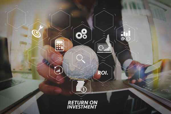 ROI Return on Investment indicator in virtual dashboard for improving business. businessman hand showing texture the world  Elements of this image furnished by NAS