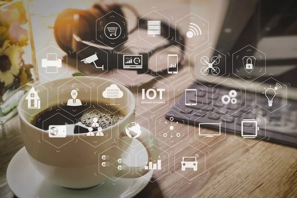 Internet of Things (IOT) technology with AR (Augmented Reality) on VR dashboard. Coffee cup and Digital table dock smart keyboard,vase flower herbs,music headphone,eyeglasses on wooden table,filter effect