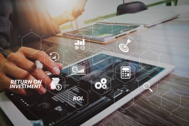 Yatırım getirisi getirisi yatırım göstergesi iş geliştirmek için sanal tablosu içinde. İşadamı el dijital tablet dokunmadan. Fotoğraf Finans Yöneticisi yeni yatırım proje ofisi çalışma. Yeni teknoloji aygıt kullanma.
