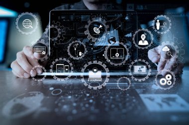 E-öğrenme bağlı Dişli çarkları ile diyagram sanal dashboard.business adam el dizüstü bilgisayarla iletişim dijital katman iş stratejisi ve sosyal medya diyagramı ahşap masa üzerinde çalışmaya bağlı  