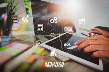 Yatırım getirisi getirisi yatırım göstergesi iş geliştirmek için sanal tablosu içinde. kavram olarak ahşap masa boş ekran dijital tablet bilgisayar ve akıllı telefon ve dizüstü bilgisayar çalışma iş adamı