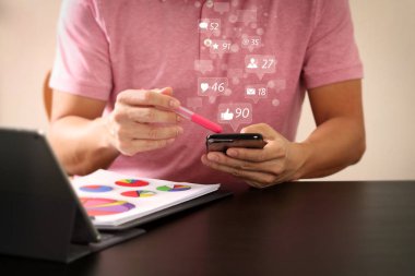 Sosyal medya ve pazarlama sanal simgeler pembe tişört modern ofis ahşap masa üzerinde akıllı telefon ve digitl tablet bilgisayar çalışma concept.businessman ekran 