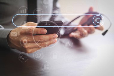 Sanal gerçeklik ile ahşap masa üzerinde cep telefonu ve kavram iletişim çağrı merkezi ile VoIP kulaklık kullanarak boş arama bar.businessman ile tarama Internet veri bilgi kavramı ağ arama.