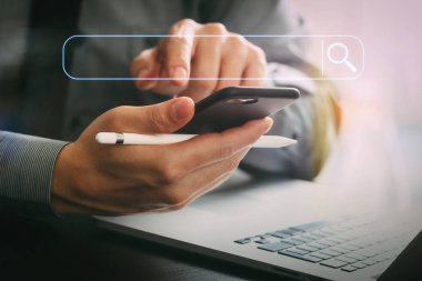 Modern ofis ahşap masa üzerinde cep telefonu ve stylus kalem ve dizüstü bilgisayar ile çalışma boş arama bar.businessman ile tarama Internet veri bilgi kavramı ağ arama 