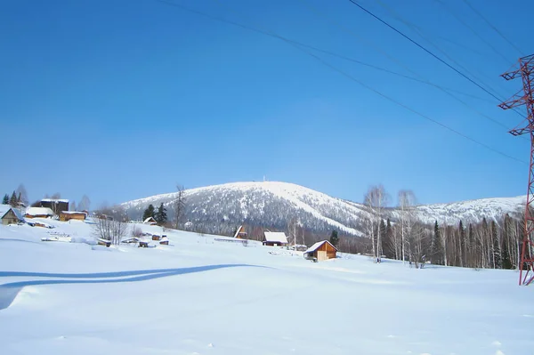 Paesaggio Invernale Con Villaggio Innevato Piedi Della Catena Montuosa Ondulata — Foto Stock