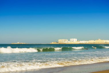 Güneşli bir günde deniz dalgaları. Cadiz 'deki Santa Maria del Mar plajı.