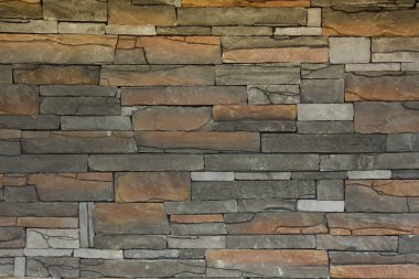 Duvar grisi ve bej yatay taşlar.