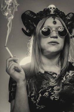 Yeşil üzerine sigara içen acımasız boynuzlu kız.