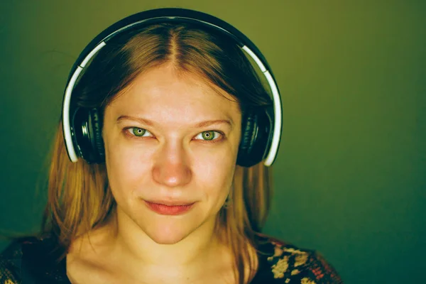 Girl Green Eyes Listening Music Headphones Green Background — Stock Photo, Image