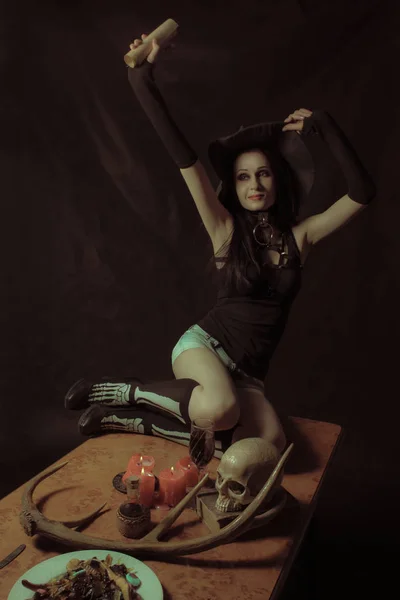 Красивая Ведьма Свитком Сидящая Столе Сером Фоне — стоковое фото