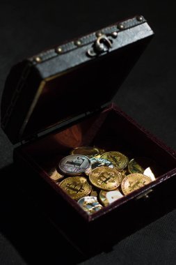 Cryptocurrencies bir göğüs koyu arka plan üzerine yığını