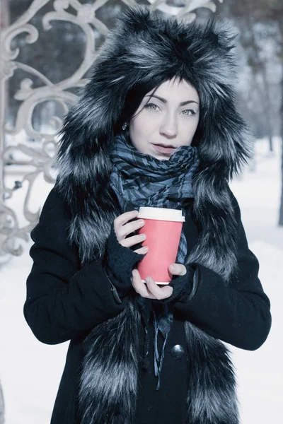 可爱的美丽女孩举行咖啡在一个冬季公园 — 图库照片