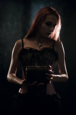 Göğüs ile koyu arka plan üzerinde poz üzücü oldukça Gotik kız