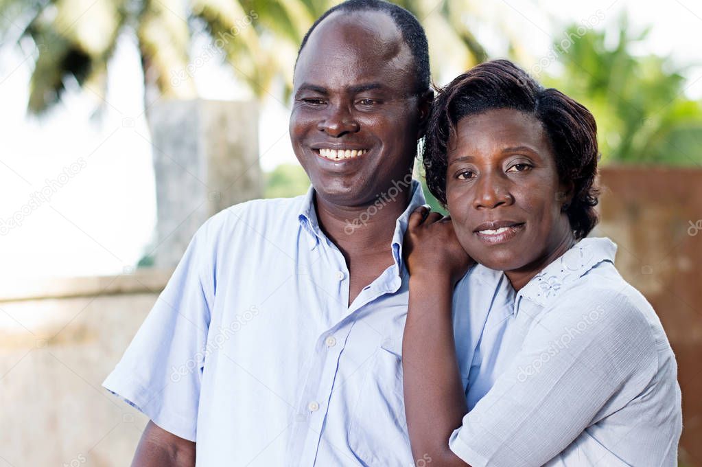 young young woman runs her husband by putting her hands on his  shoulder.