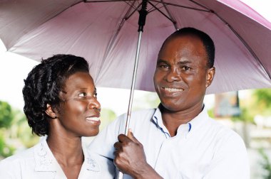 Genç mutlu çift başlarını yanan güneşin karşı korumak.