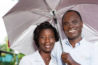 Genç mutlu çift başlarını yanan güneşin karşı korumak.