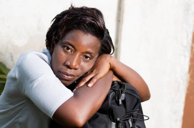 kafasına torba bekleyen arabası ile oturan genç kadın.