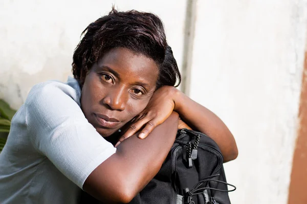 kafasına torba bekleyen arabası ile oturan genç kadın.