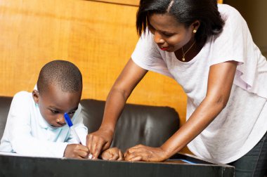 Anne çocuğunu onun defterine yazmak bulunduğu gösterir.