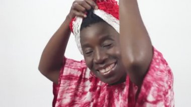 Genç Afrikalı kadın kırmızı beyaz kaşkollu duvak ekler..