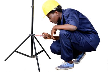 Genç kadın çömelmiş bir tripod kaldırır.