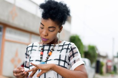 Genç Afrikalı kadın ayakta dışında ve tırnaklarını Temizleme.