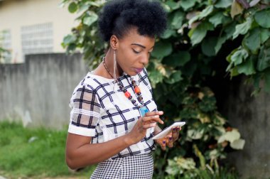 Güzel genç Afrika iş kadın onun cep telefonuna kısa mesaj okuma