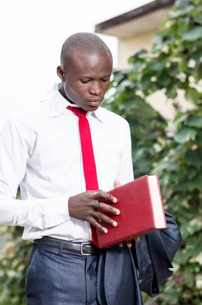 Açmak için bir kitap ve hazır tutan genç öğrenci.