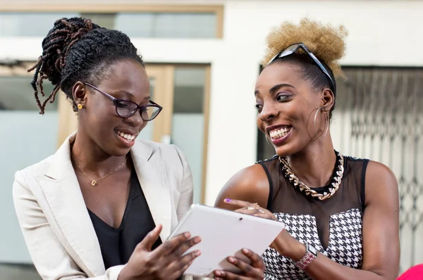 smiling businesswomen with tablet computers having discussion outdoor