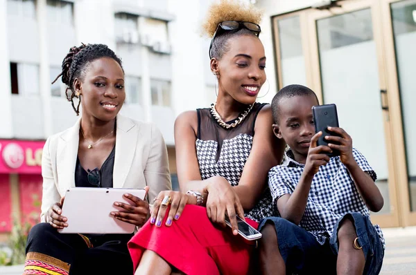 Little Boy Handling Mobile Phone Impressed Two Young Women Sitting — Stock Photo, Image